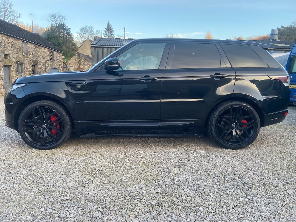 Finished Range Rover Sport in gloss black with black alloy wheels and red brake calipers, parked outside after the respray