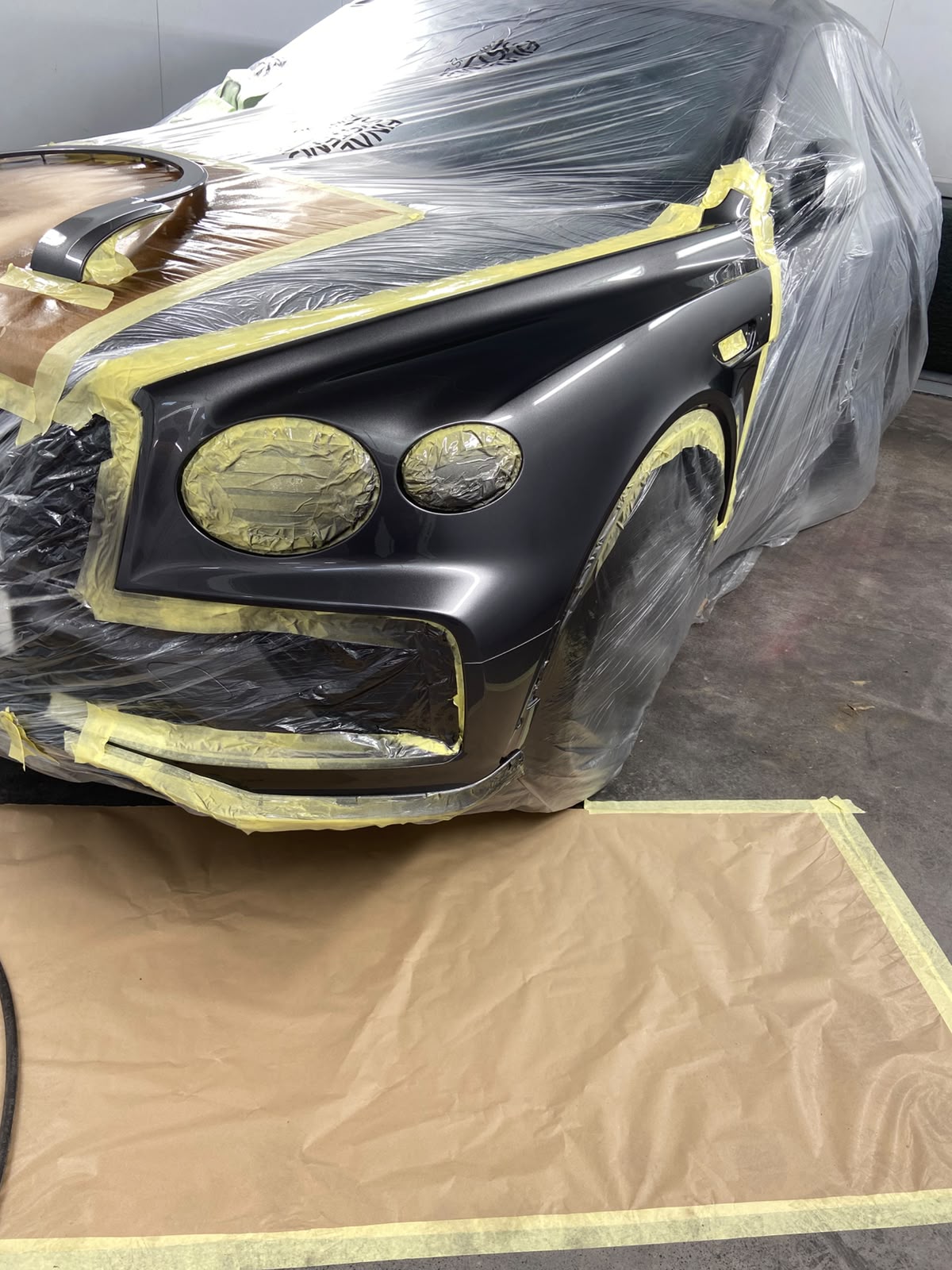 Close-up of the masked Bentley Bentayga wing and bumper, prepared for colour matching