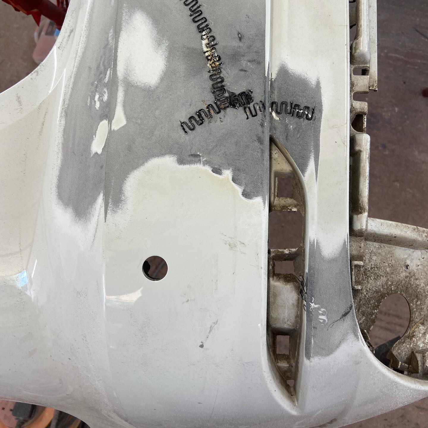 Underside of the bumper showing plastic welding staples used to repair the crack