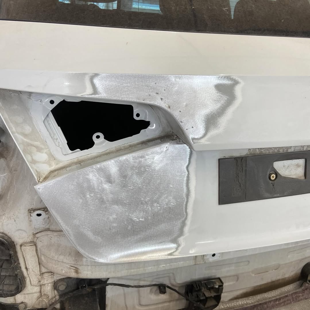 Close-up of the repaired bumper corner and the tail light housing, replaced with a genuine recycled part