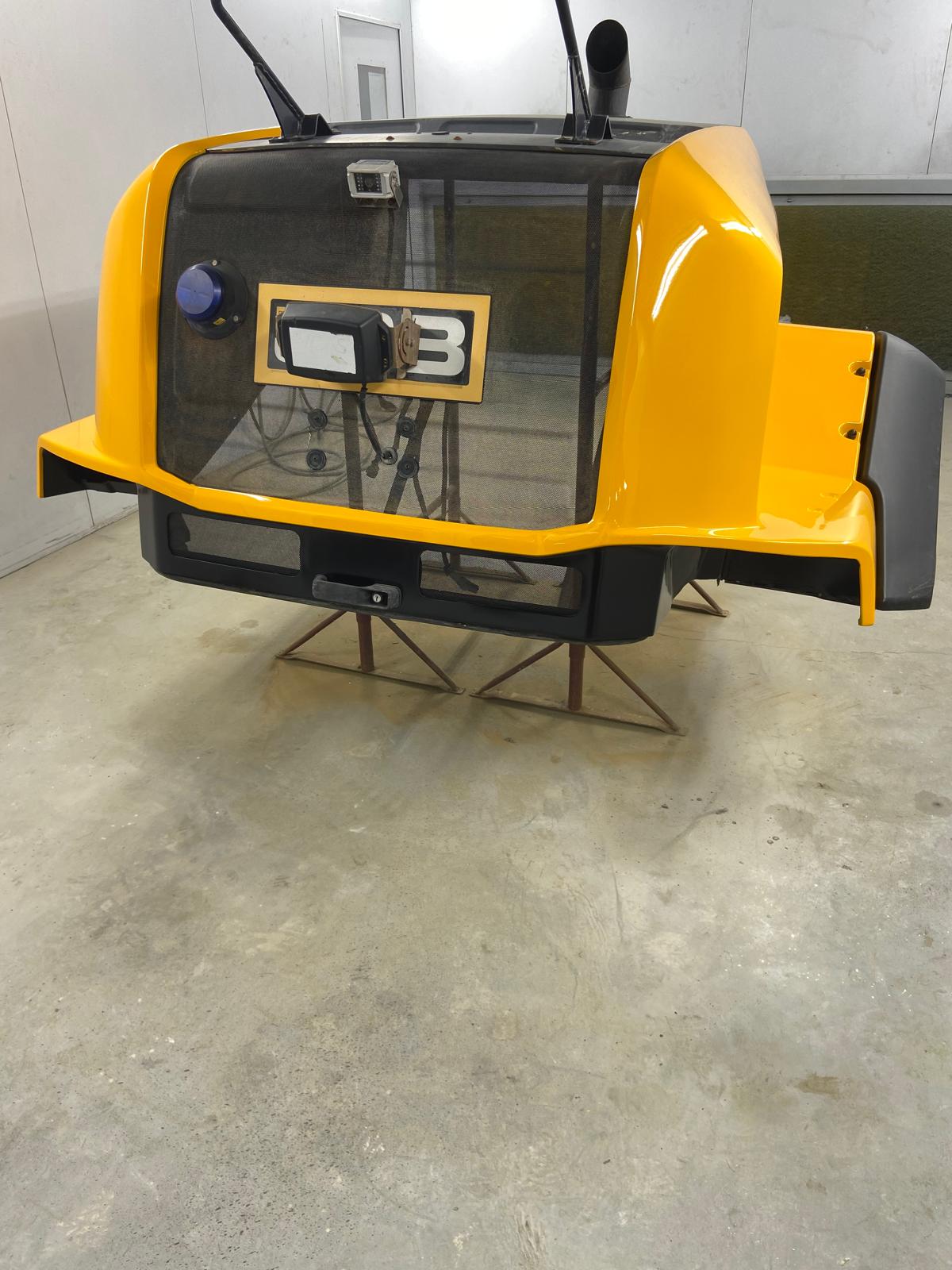 Finished JCB loading shovel bonnet panel back in gloss yellow, with the mesh guard and badge refitted